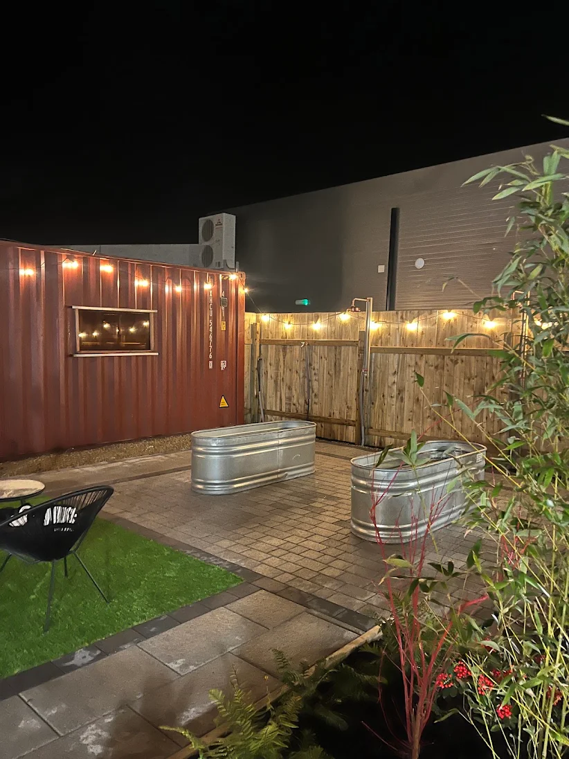 Two cold plunge pools on the patio, with outdoor showers along the fence